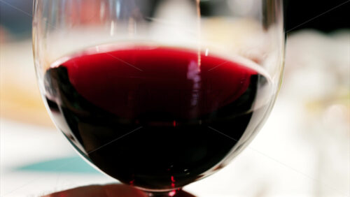 Close up of a glass of red wine being swirled showcasing the rich ruby colour - Starpik Stock