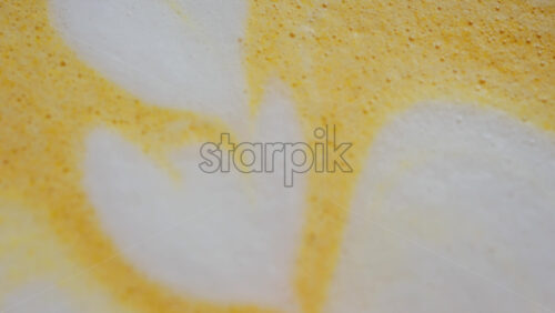 Close up of a heart-shaped latte art in golden turmeric coffee - Starpik Stock
