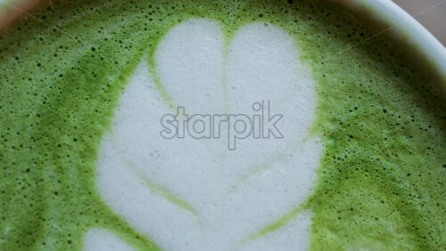 Close up of a matcha latte on a wooden table - Starpik Stock