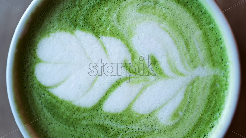 Close up of a matcha latte on a wooden table. Vertical - Starpik Stock