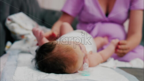 Close up of a mother doing mobility exercises with her baby - Starpik Stock
