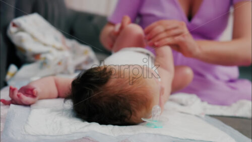 Close up of a mother doing mobility exercises with her baby - Starpik Stock