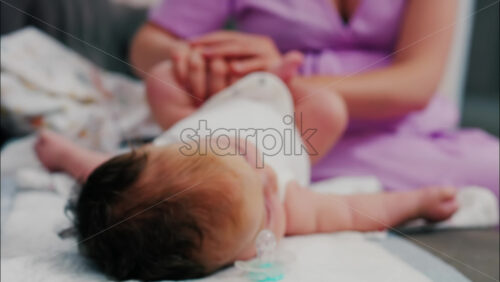Close up of a mother doing mobility exercises with her baby - Starpik Stock