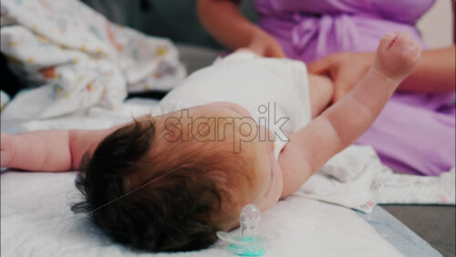 Close up of a mother doing mobility exercises with her baby - Starpik Stock