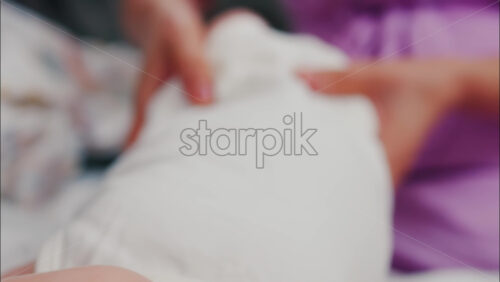 Close up of a mother doing mobility exercises with her baby - Starpik Stock