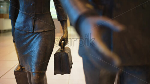 Close up of a pilot and two flight attendants holding luggages sculpture at the Chisinau International Airport in Moldova - Starpik Stock