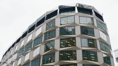 Close-up of a unique office building facade with angled, geometric window frames in London, England near the financial center - Starpik Stock