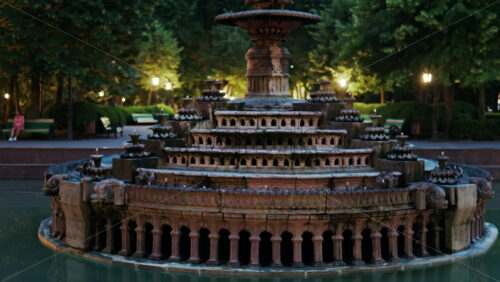 Close up of a water fountain in the Stephen the Great Central Park in Chisinau, Moldova with golden lights in the background - Starpik Stock