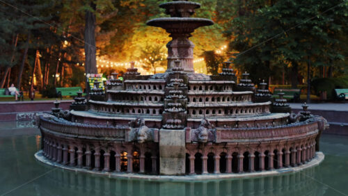 Close up of a water fountain in the Stephen the Great Central Park in Chisinau, Moldova with golden lights in the background - Starpik Stock