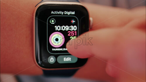 Close up of a woman changing the wallpaper on the smartwatch on her hand - Starpik Stock