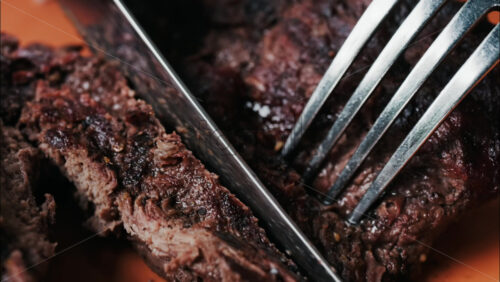 Close up of a woman’s hands cutting a Sirloin Steak with Barbecue Sauce and micro-plants on the side - Starpik Stock