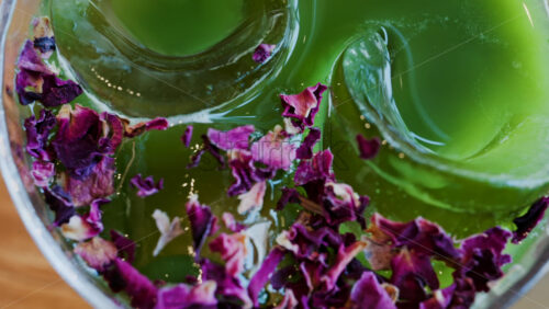 Close up of an iced matcha in a glass with purple dried flowers on top - Starpik Stock