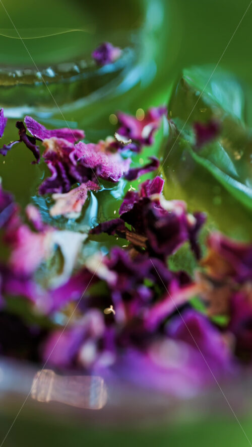 Close up of an iced matcha in a glass with purple dried flowers on top. Vertical - Starpik Stock