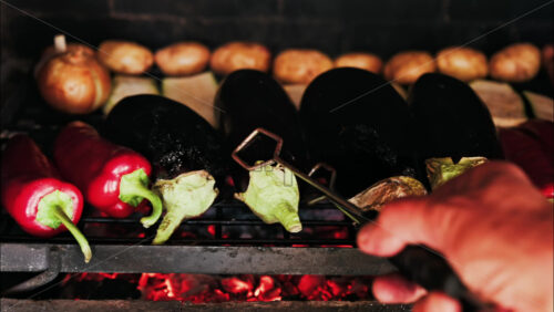 Close up of eggplants, potatoes, onions, peppers and courgettes cooking on a grill - Starpik Stock