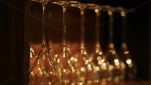 Close up of empty glasses turned upside down on a shelf - Starpik Stock