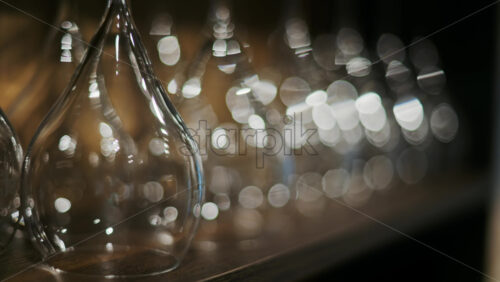 Close up of empty glasses turned upside down on a shelf - Starpik Stock