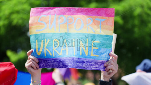 Close up of hands holding rainbow sign reading “Support Ukraine” at the Pride March in Chisinau, Moldova - Starpik Stock