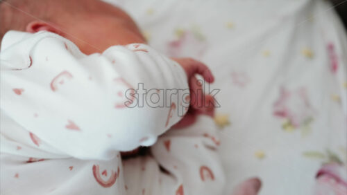 Close up of newborn’s hand gently clenched near the face, capturing delicate skin texture - Starpik Stock
