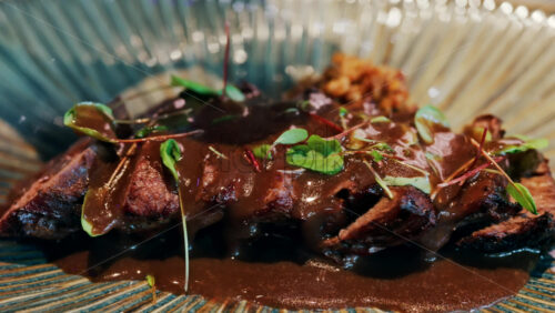 Close up of sauce being poured on a grilled steak at a restaurant - Starpik Stock