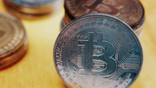Close up of shiny physical Bitcoin coins stacked on a table - Starpik Stock
