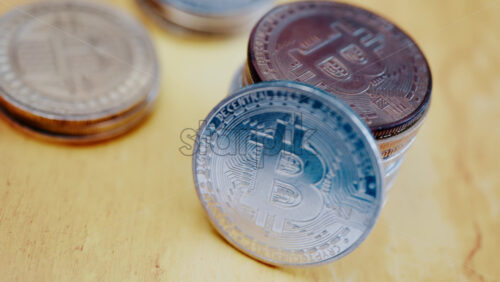 Close up of shiny physical Bitcoin coins stacked on a table - Starpik Stock