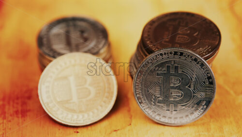 Close up of shiny physical Bitcoin coins stacked on a table - Starpik Stock