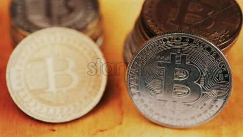 Close up of shiny physical Bitcoin coins stacked on a table - Starpik Stock