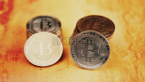 Close up of shiny physical Bitcoin coins stacked on a table - Starpik Stock