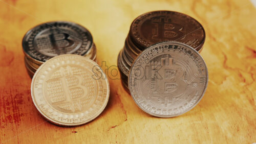 Close up of shiny physical Bitcoin coins stacked on a table - Starpik Stock