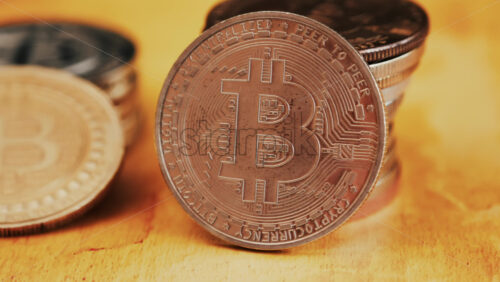 Close up of shiny physical Bitcoin coins stacked on a table - Starpik Stock
