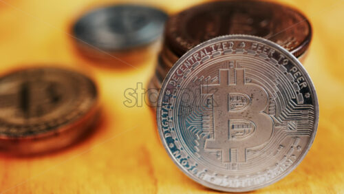Close up of shiny physical Bitcoin coins stacked on a table - Starpik Stock