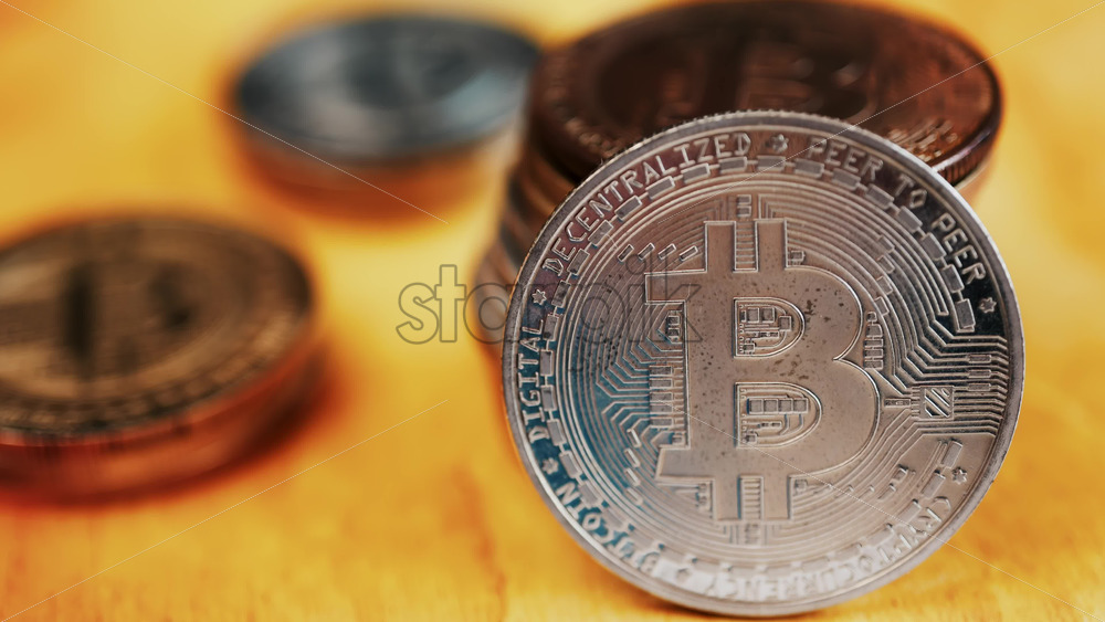 Close up of shiny physical Bitcoin coins stacked on a table - Starpik Stock