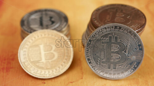 Close up of shiny physical Bitcoin coins stacked on a table - Starpik Stock