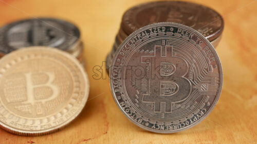 Close up of shiny physical Bitcoin coins stacked on a table - Starpik Stock