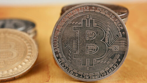 Close up of shiny physical Bitcoin coins stacked on a table - Starpik Stock