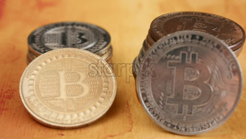 Close up of shiny physical Bitcoin coins stacked on a table - Starpik Stock