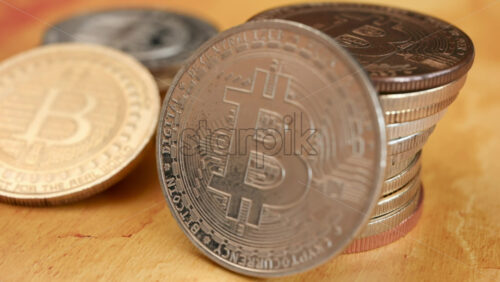 Close up of shiny physical Bitcoin coins stacked on a table - Starpik Stock