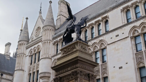 Close up of the Temple Bar dragon statue and intricate Gothic architecture of the Royal Courts of Justice, London, England - Starpik Stock
