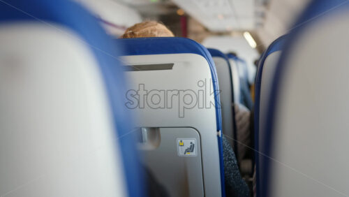 Close up of the back of chairs on a moving airplane - Starpik Stock