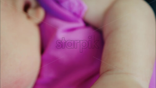 Close up view of a baby’s hand and fingers curled in a natural pose while resting - Starpik Stock