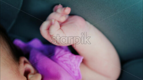 Close up view of a baby’s hand and fingers curled in a natural pose while resting - Starpik Stock