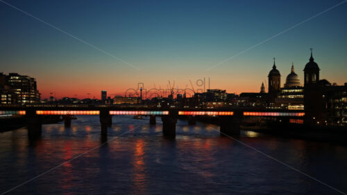 Colourful lights from Cannon Street Railway Bridge reflecting on the Thames River at twilight with St. Paul’s Cathedral in the background in London, England - Starpik Stock