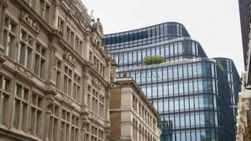 Contrast view of traditional Victorian-style buildings alongside sleek, modern glass office blocks in London, England - Starpik Stock