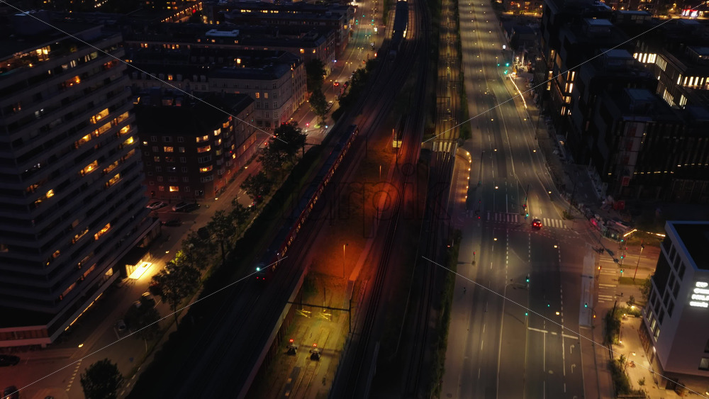 Copenhagen, Denmark – August 3, 2025: Aerial drone view at night of a quiet street and train tracks near Vesterport Station - Starpik Stock