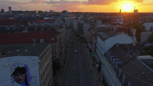 Copenhagen, Denmark – August 3, 2025: Aerial drone view of cars moving between the buildings, on the streets of the city at sunset - Starpik Stock