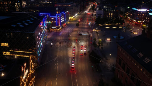 Copenhagen, Denmark – August 3, 2025: Aerial drone view of the Copenhagen intersection at Vesterbrogade near Radhuspladsen at night with neon signs - Starpik Stock