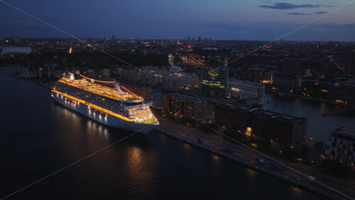 Copenhagen, Denmark – August 3, 2025: Aerial drone view of the illuminated Crystal Serenity cruise ship docked at Copenhagen Cruise Terminal, Nordhavnen - Starpik Stock