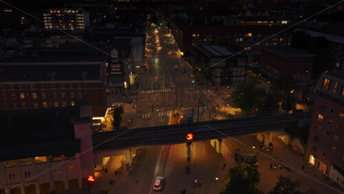 Copenhagen, Denmark – August 4, 2025: Aerial drone view of Norrebro Station and surrounding city lights, with S-train tracks illuminated - Starpik Stock
