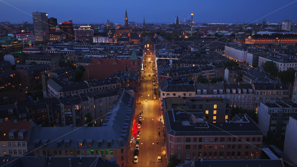 Copenhagen, Denmark – August 4, 2025: Aerial drone view of a lively street illuminated by cars, bicycles, and pedestrians in Norrebro - Starpik Stock