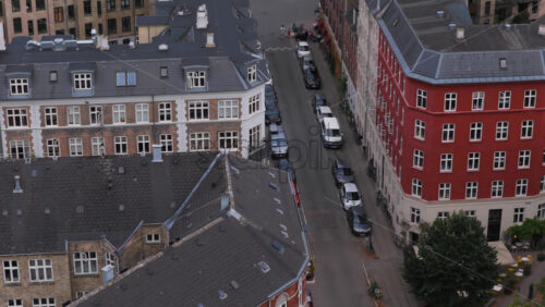 Copenhagen, Denmark – August 4, 2025: Aerial drone view of a red-and-white apartment building in Norrebro with a large, colorful mural on the adjacent wall - Starpik Stock